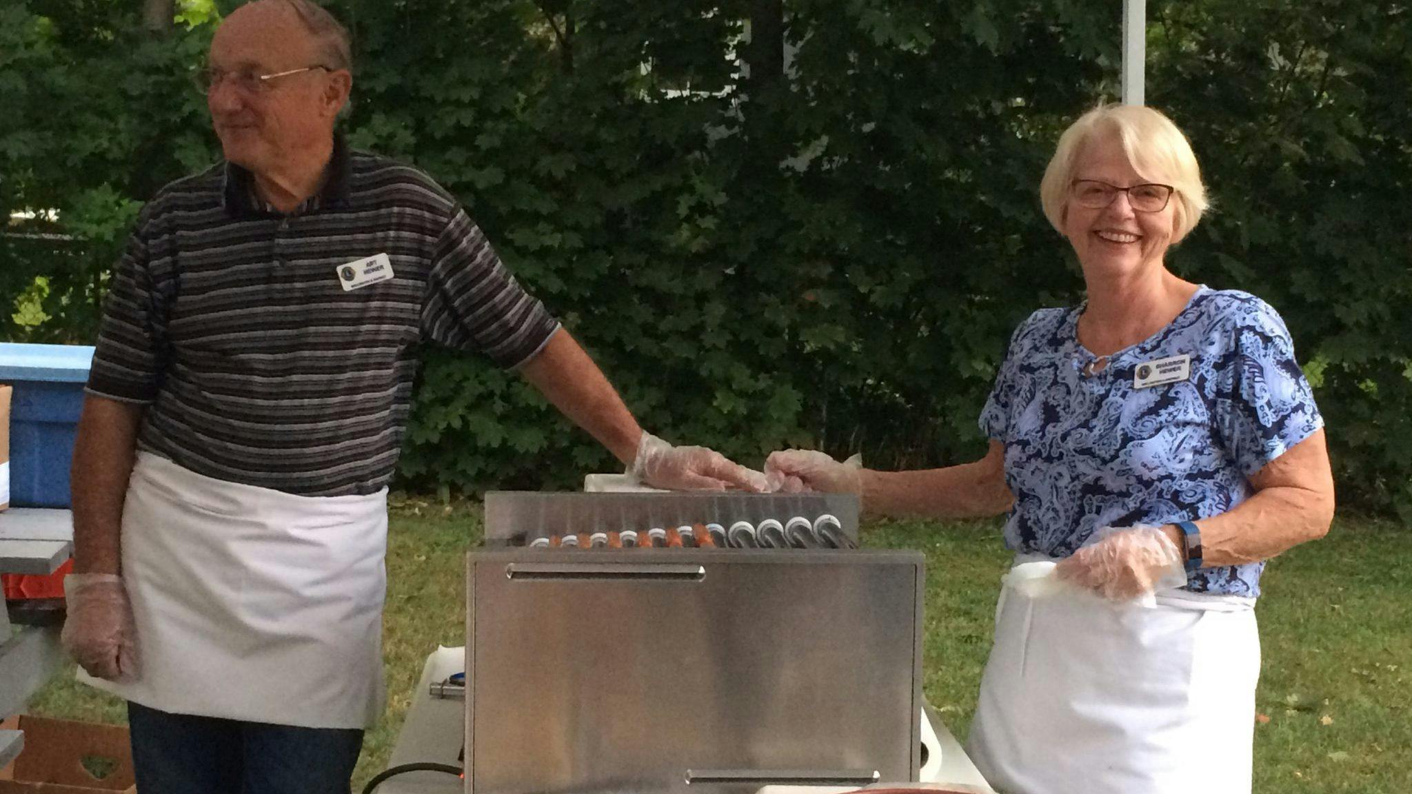 <p>LIONS ROAR- Wellington Lions club members Art and Sharon Hewer tend to hot dogs at a concert in Wellington Park. (Submitted Photo)</p>
